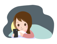 A woman looking at a smartphone in a futon before going to bed